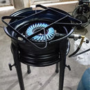 Fogão industrial a gás com chama azul, estrutura metálica preta e três pernas, usado em cozinhas profissionais