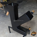 Churrasqueira pré-moldada metálica preta em formato moderno com alças de madeira sobre piso de concreto